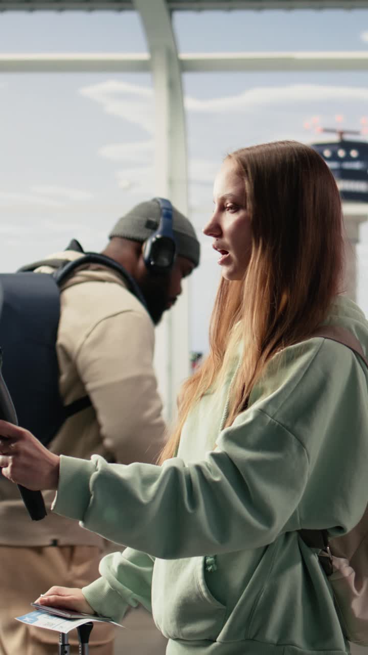 Video verticale: Content creator (ragazza) che usa il telefono su treppiede per registrare un vlog in una lounge aeroportuale
