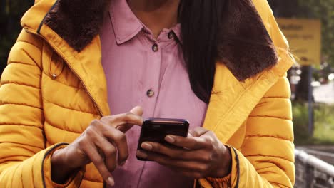 Mid-Section-Young-Woman-Texting-and-Enjoying-Walk-by-Canal