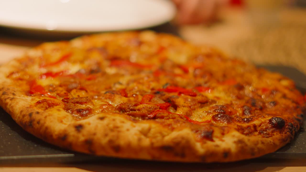 Slow Rotating View of BBQ Chicken Pizza Served to Customers with Diners in Background with Empty Plates Waiting to Eat. Italian Food Cuisine Meal.
