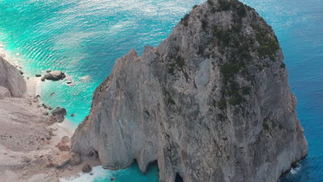 Tiro-De-Drone-De-Playa-Aislada-Bajo-Acantilados-Y-Formación-Rocosa-De-La-Isla-De-Zakynthos,-Grecia