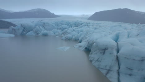toma aérea baja junto al borde de un gran glaciar
