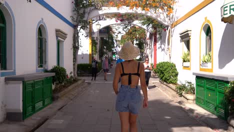 vista trasera de la mujer camina por las calles del casco antiguo de la ciudad blanca en la playa de callao, gran canaria, islas canarias, españa