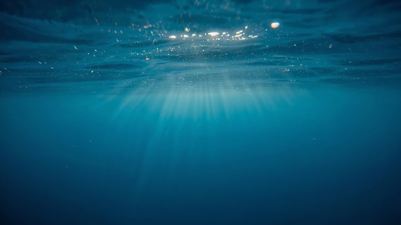 水中の柱を通過して太陽光線を送る表面の動きの変化、太陽のまぶしさや粒子を示しています。