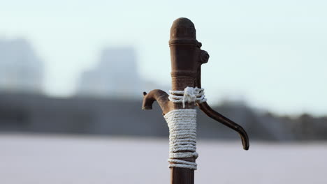 Rusty-old-metal-water-pump-on-sand-beach