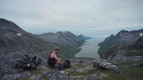 joven excursionista activo con malamute de alaska en el paisaje montañoso del parque nacional anderdalen en senja, noruega