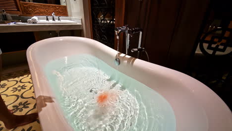 bathtub getting filled with water inside a hotel room