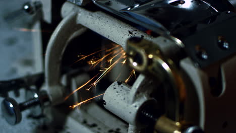 Sparks-while-grinding-iron-in-workshop.-Close-up-working-grinding-machine
