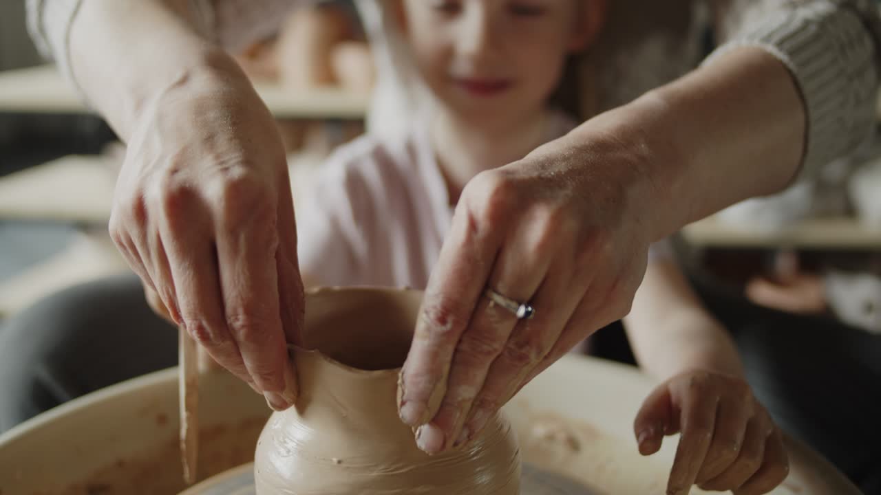 la abuela enseña a su nieta a trabajar en una rueda giratoria de cerámica