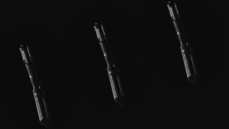 three pistols on the dark background rotate in slowmotion