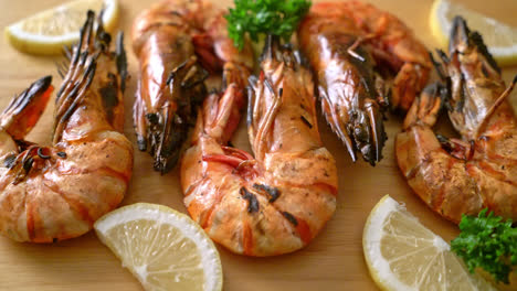 grilled tiger prawns or shrimps with lemon on wood board