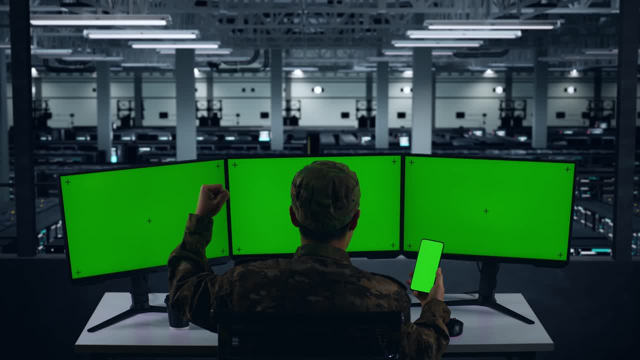 행복한 아시아 군대가 휴대 전화 녹색 화면을 보고 데이터 센터에서 여러 컴퓨터 모니터로 작업하는 동안 축하하는 뒷면