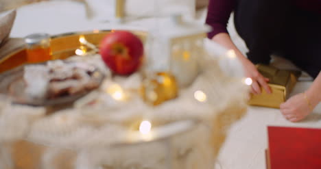 Comida-Y-Decoración-En-Mesa-Con-Mujer-Preparando-Presente