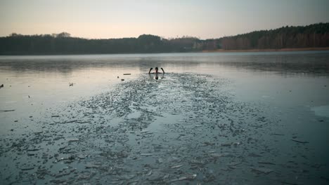 a young man in a frozen lake with open arms enjoying the swim