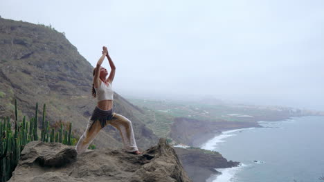 as the sun sets over the blue ocean, a young woman performs yoga on a rocky seashore, representing a healthy lifestyle, harmony, and the interconnectedness of humans and nature