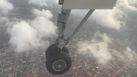 airplane aircraft boeing wheel above cityscape up in the air with white clouds