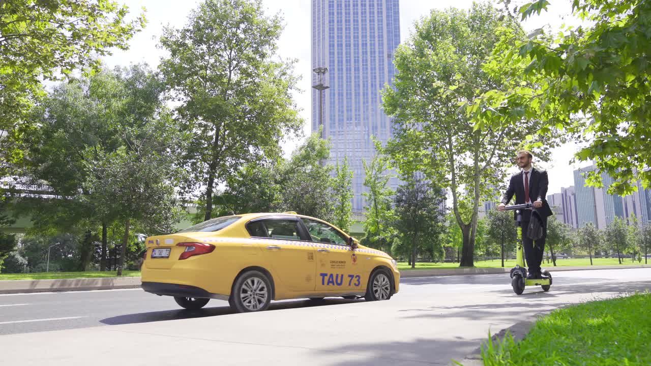 길을 따라 전기 스쿠터를 타고 있는 사업가의 측면 전망.