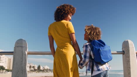 mother and son holding hands at beach