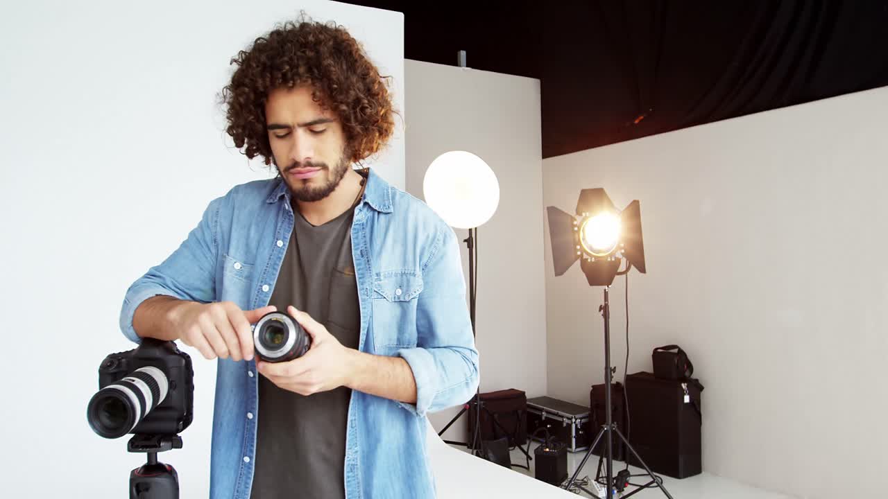 Fotografo che controlla l'obiettivo della fotocamera