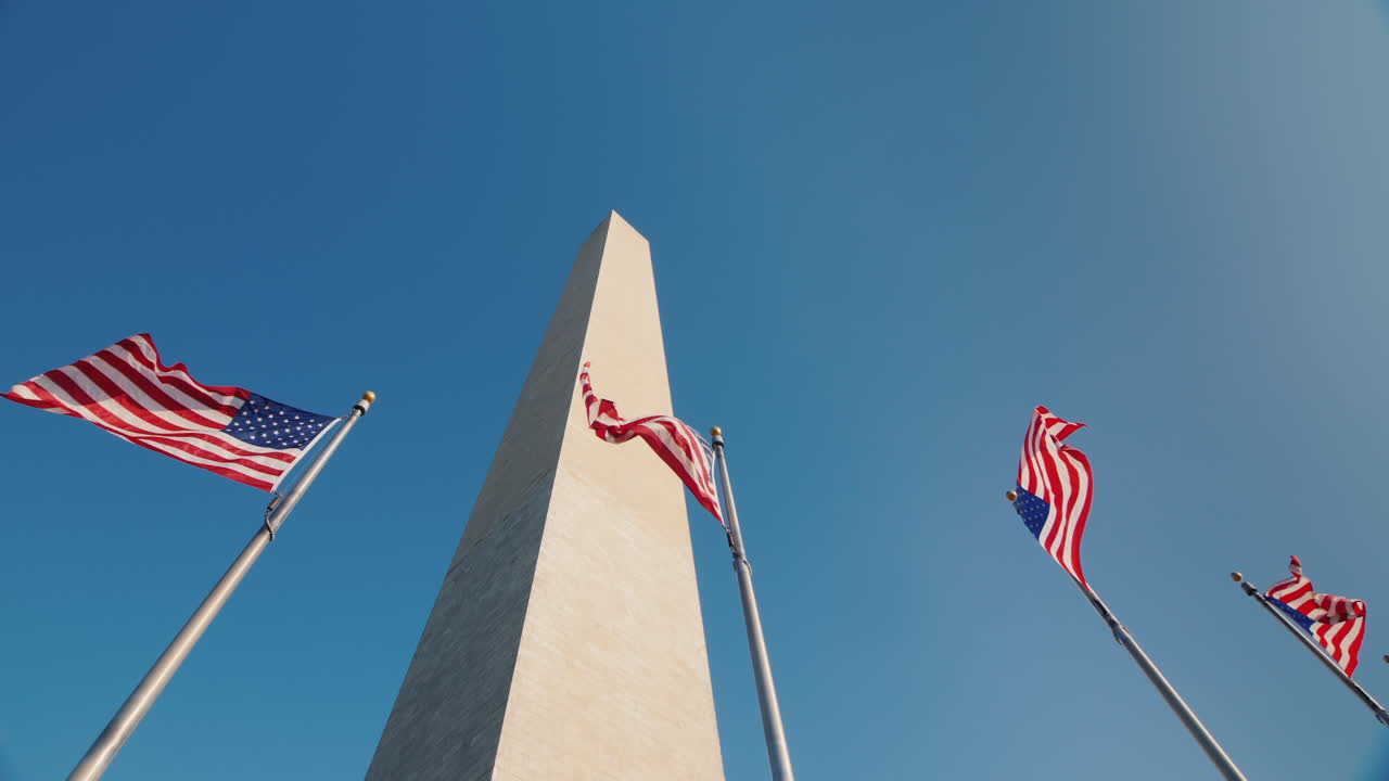 Monumento a Washington a D.C., USA, con bandiere americane che sventolano, ripresa dal basso