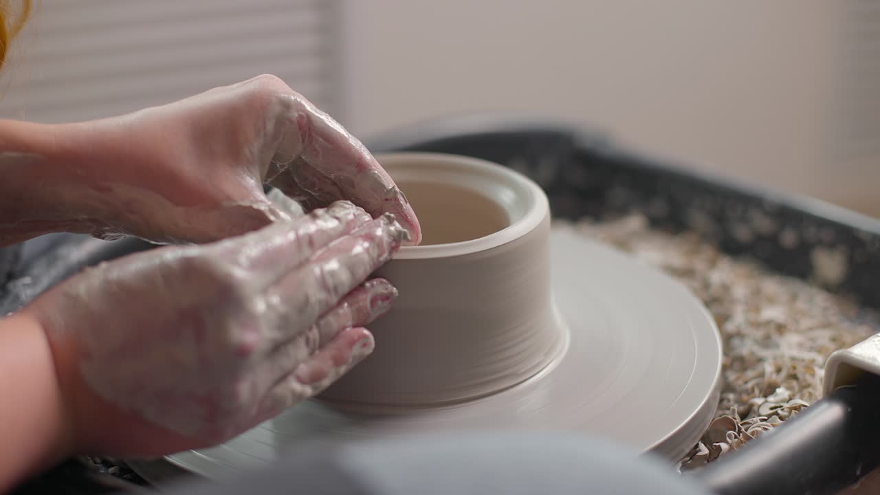 도자기의 바에 일하는 도자기의 손의 클로즈업, 점토의 그을 형성하는 느린 모션