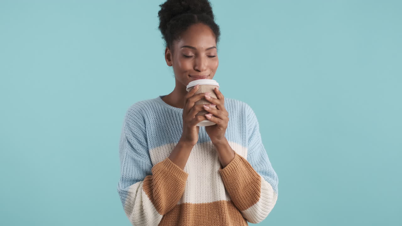 뜨거운 커피를 마시는 웃는 소녀