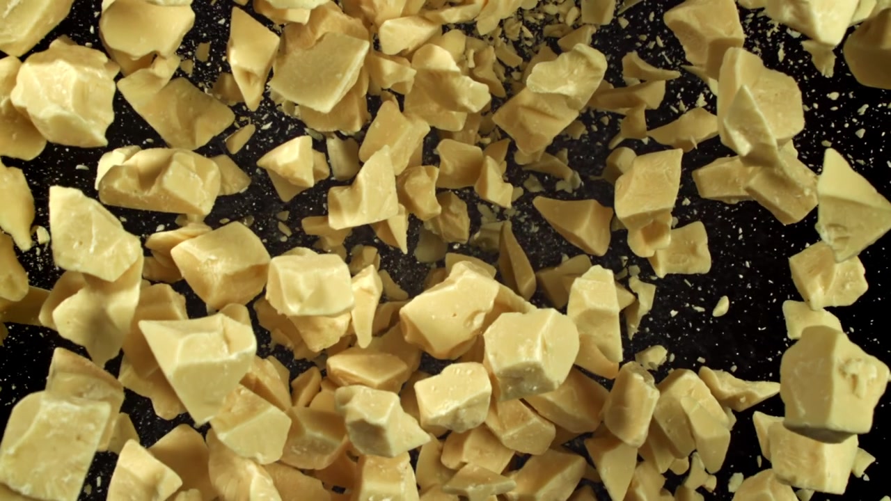 Super Slow Motion of White Chocolate Chunks Falling on Black Background