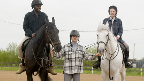 two friends getting ready to ride two horses