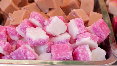 pink and white coconut ice sweets on a street food market stall.
