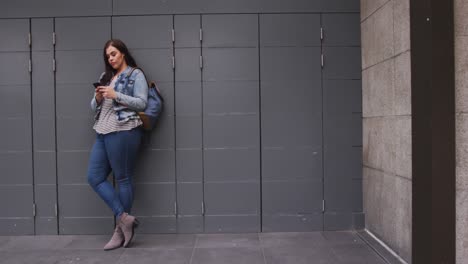 young caucasian woman standing and holding phone