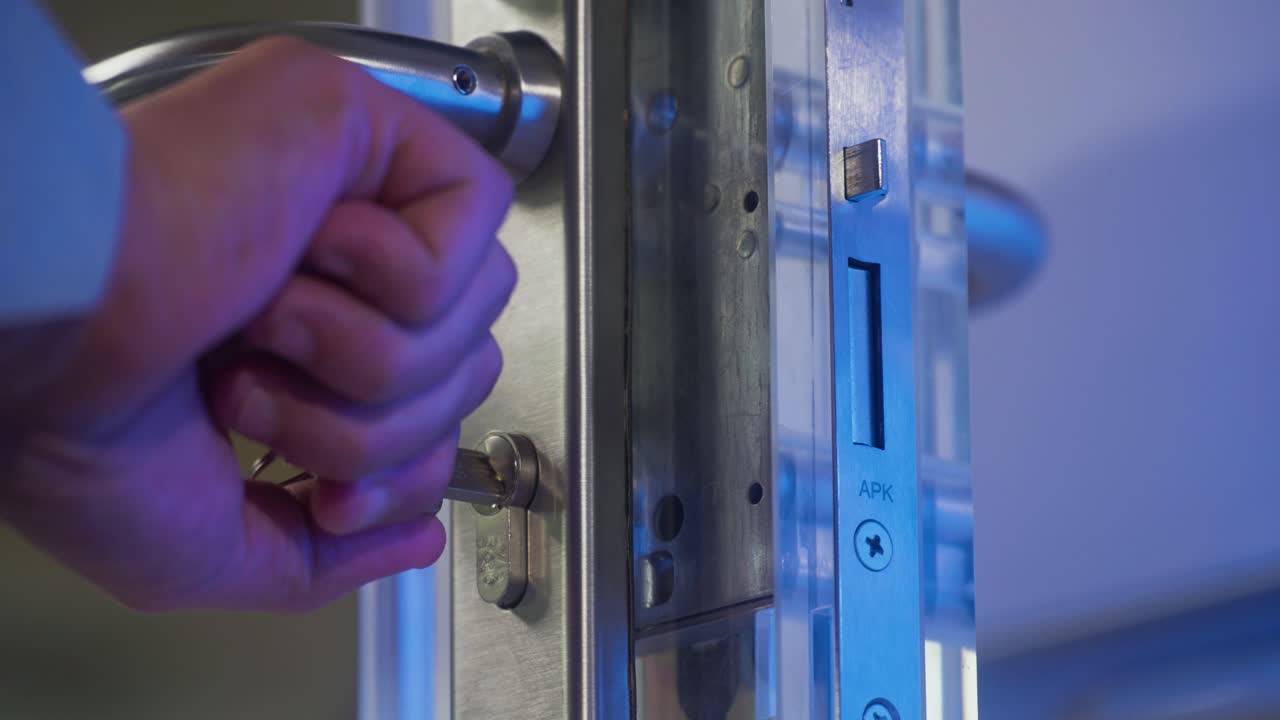 un hombre poniendo una llave en una puerta y abriéndola