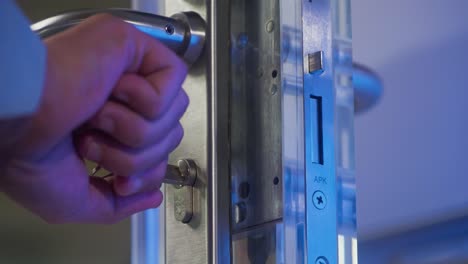 a man putting a key in a door and unlocking it