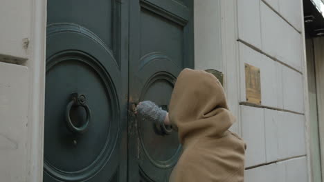 woman opening entrance door and coming in