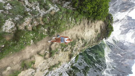 Aerial-drone-view-of-beautiful-blonde-girl-walks-off-the-Cadini-Di-Misurina-Viewpoint,-Dolomites,-Italy,-Europe