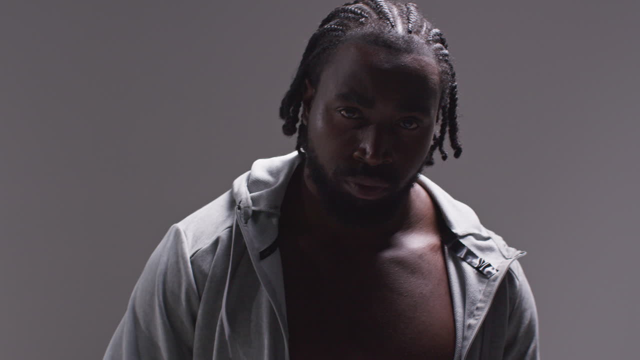 회색 배경에 대한 권투 경기에 대한 훈련을 위해 보호 붕대에 손을 감은 남성 권투 선수의 근접 초상화 1