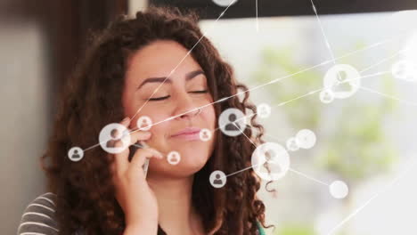 Animation-of-network-of-connections-over-biracial-woman-talking-on-smartphone