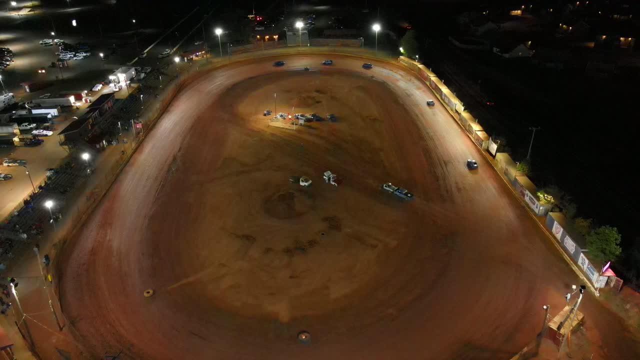 légère orbite aérienne de course sur piste ovale lors d'une course de nuit