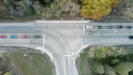 top-down aerial footage of a busy interception at night with lots of cars and trees on either side of the road outside of ottawa, ontario