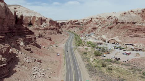 desert valley road of red rock cliffs in desert town of bluff, utah, aerial