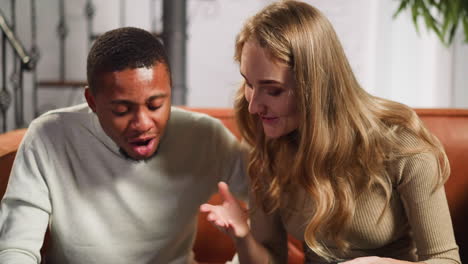 Woman-and-African-American-man-smile-looking-at-photo-album