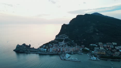 Vogelperspektive-Auf-Die-Schöne-Klippe,-Umgeben-Von-Meer-Mit-Booten-Und-Schiffen,-Die-Im-Hafen-Mit-Gebäuden-An-Der-Küste-Des-Dorfes-Portovenere-In-Italien-Geparkt-Sind