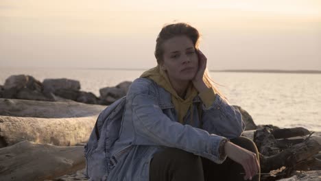 sad girl on the beach sit and thinking at sunset