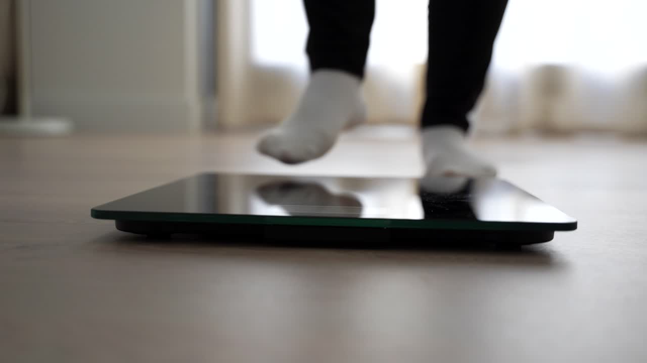 Female feet stepping on and off a scale twice. Front close up shot