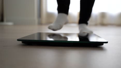 female feet stepping on and off a scale twice. front close up shot