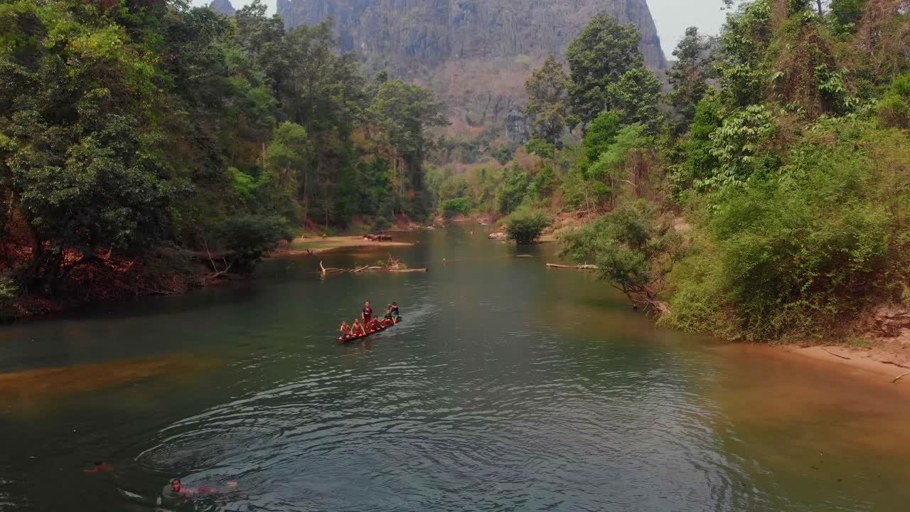 Bambini che giocano con la canoa sul fiume nella grotta di Kong Lor, Laos