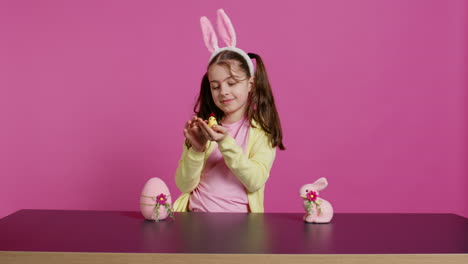 joyful little girl playing with festive easter decorations in studio