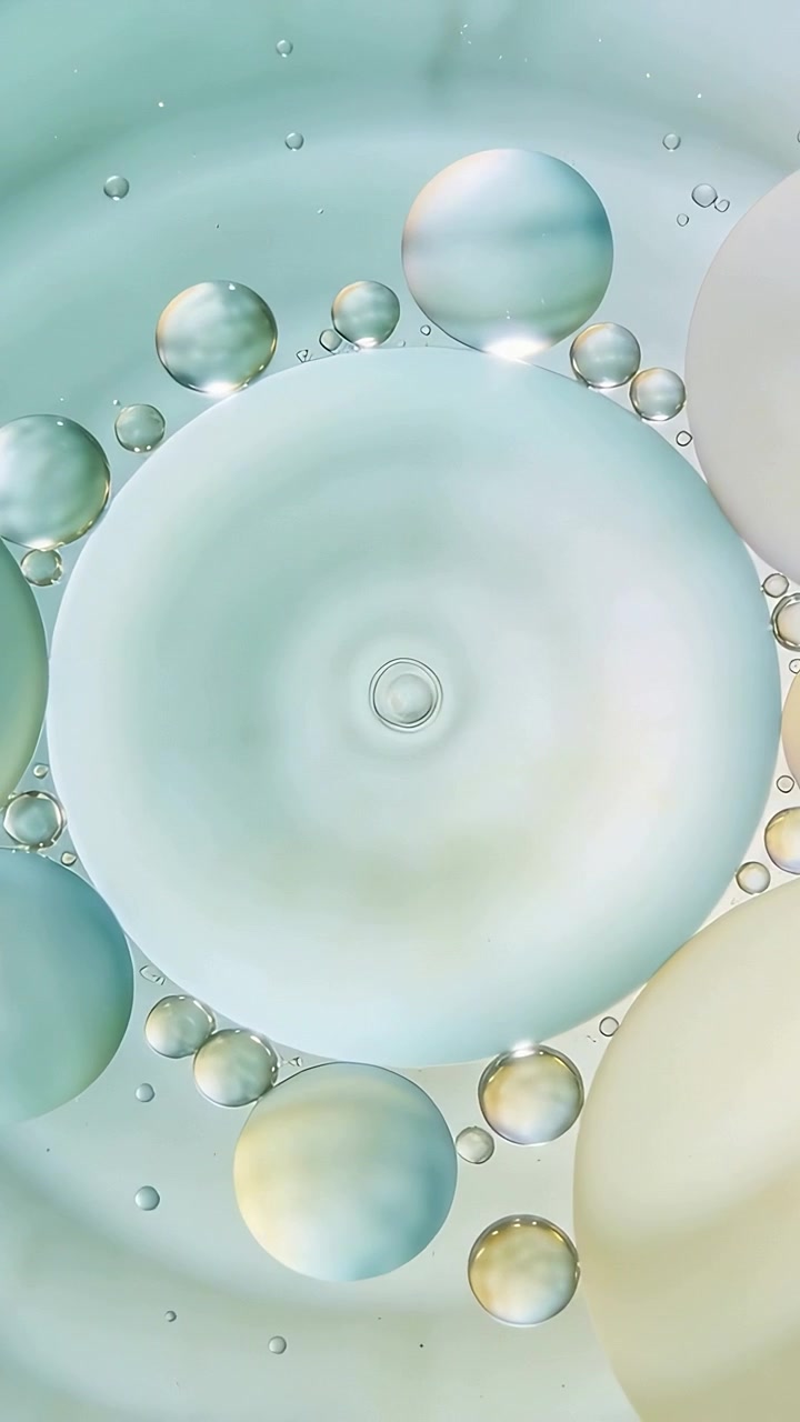 Video verticale: Disco color acqua pallido e gocce che si muovono in una cella macro mentre il movimento fluido sposta i riflessi