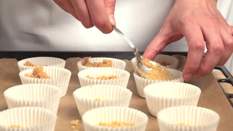 arranging cupcake bases made with biscuit and in molds on a tray