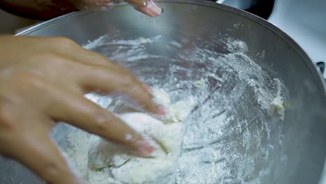 Vista-De-Cerca-De-Las-Manos-De-Una-Mujer-Afroamericana-Amasando-Masa-De-Pizza-En-Una-Sartén-Plateada-En-Cámara-Lenta