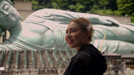 beautiful young latin woman tourist enjoy visit to nanzoin temple daibutsu giant bronze buddha statue at fukuoka japan