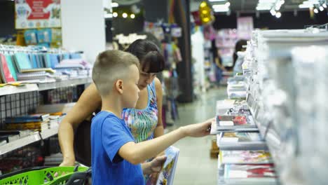 vinnitsa, ukraine - august 20, 2018: back to school concept. young mother and little boy buying school supplies in store.